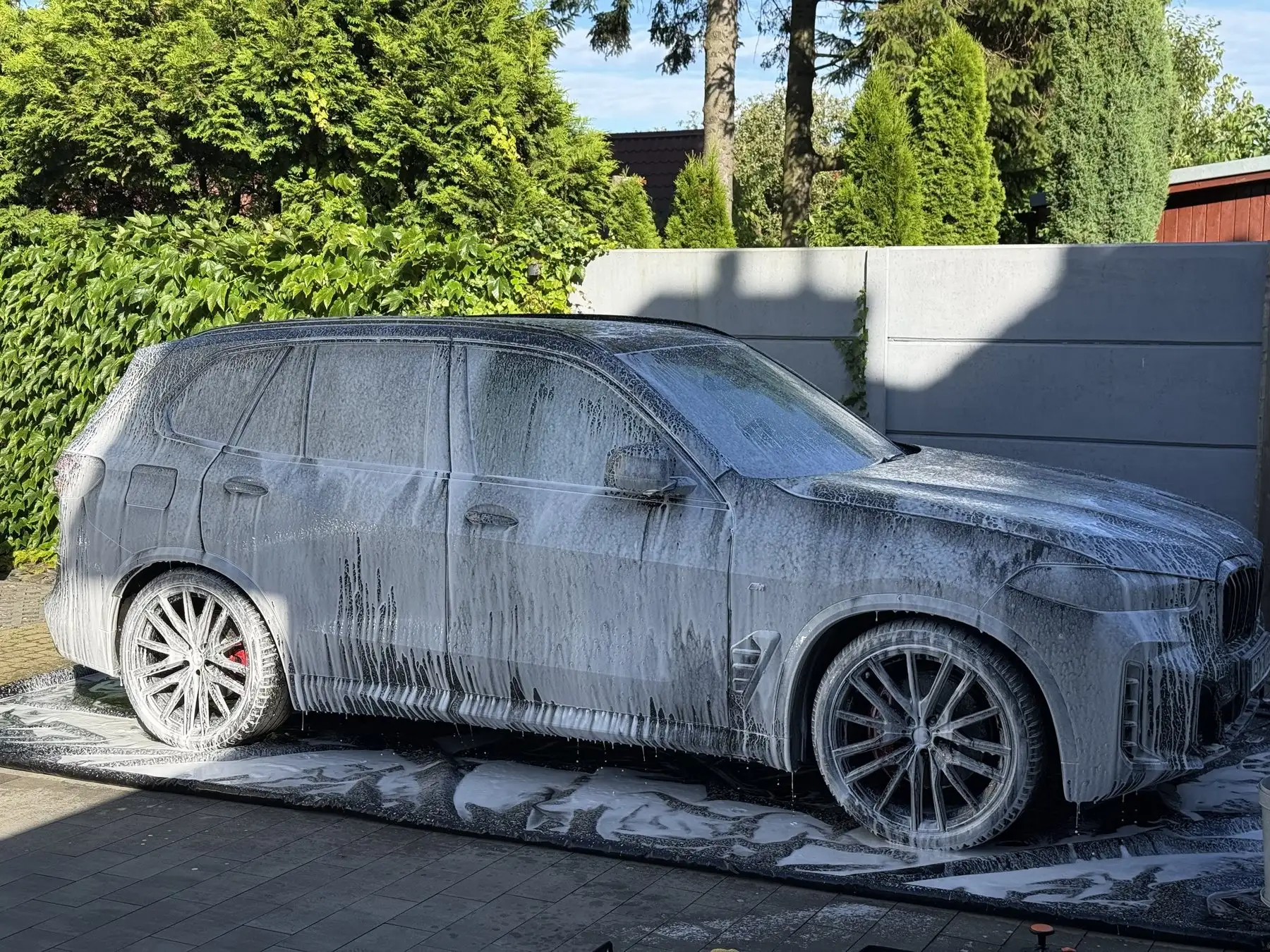 BMW X5 pokryte pianą aktywną podczas mycia na podjeździe klienta